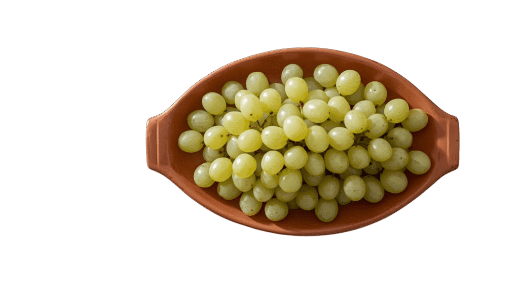 Fresh green grapes arranged in a brown ceramic bowl, photographed from above against a neutral background.