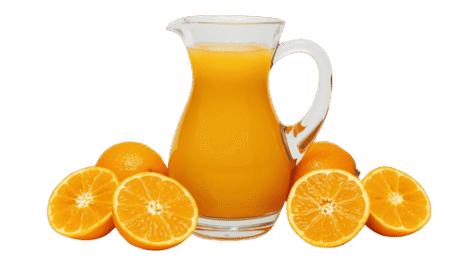 A clear glass pitcher filled with orange juice, surrounded by whole and halved fresh oranges on a solid teal background.