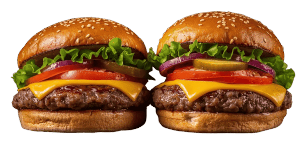 Two cheeseburgers side by side on a solid teal background, each with a sesame seed bun, beef patty, melted cheese, tomato slices, red onion, pickles, and leafy lettuce.